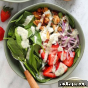 A bowl of fresh Strawberry Spinach Salad, featuring vibrant greens, sliced red strawberries, and a light dressing, perfect for a healthy meal.