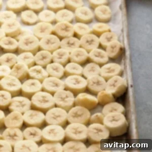 Wholesome Banana Bliss 2 Sliced bananas laid out on a baking sheet, ready for freezing.