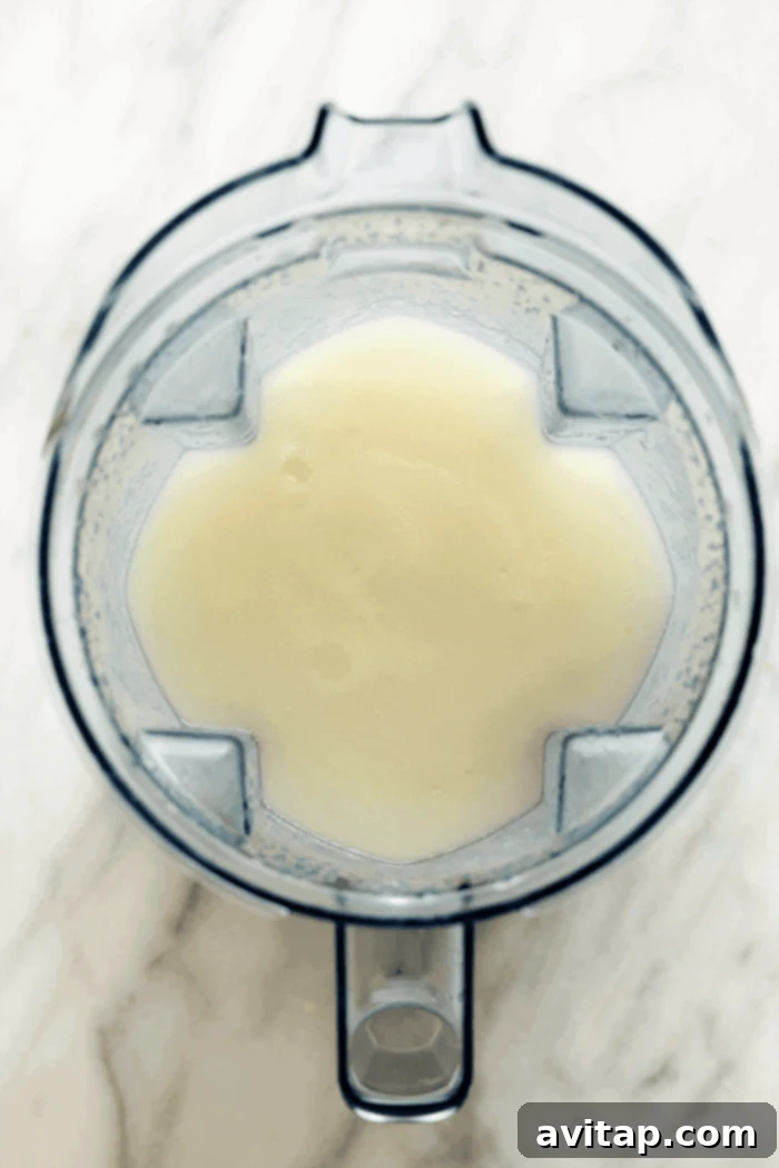 A close-up of a frozen margarita being blended in a Vitamix, showing the smooth, icy texture.