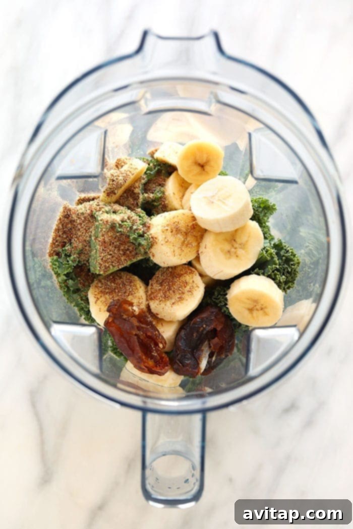 Fresh ingredients for a kale smoothie neatly arranged in a blender, ready to be blended.