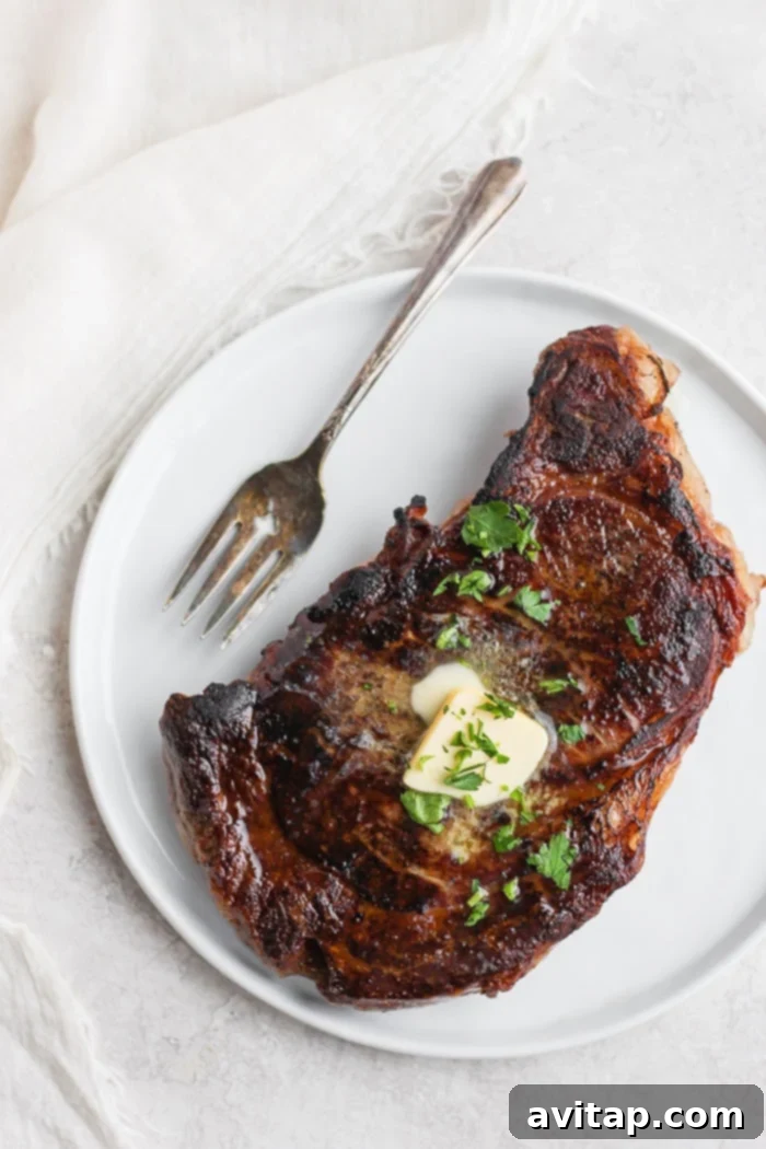 Perfectly cooked sous vide steak garnished with butter and fresh parsley, ready to serve.