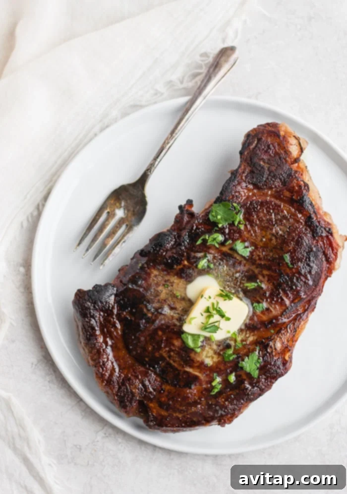 Exquisite sous vide steak, beautifully seared and topped with a melting pat of herb butter.