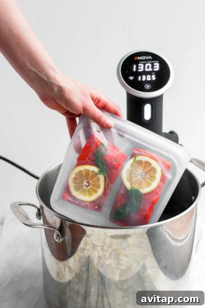 Sous vide salmon fillets being placed into the water bath.