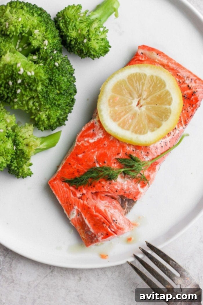 Sous vide salmon served on a plate with a side of vibrant green broccoli.