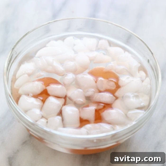 Freshly baked hard-boiled eggs undergoing an essential ice bath, crucial for easy peeling and stopping the cooking process.