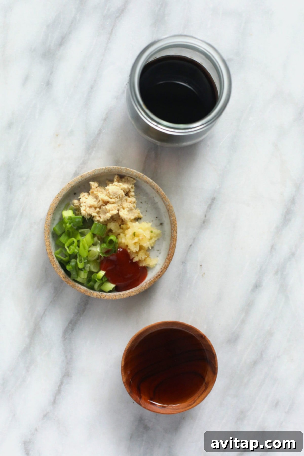 Fresh Ingredients for Teriyaki Sauce Individual ingredients for homemade teriyaki sauce laid out: soy sauce, maple syrup, minced garlic, and fresh ginger.