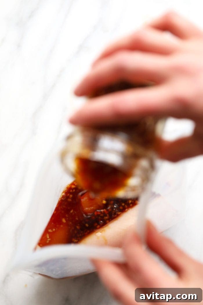Pouring Homemade Teriyaki Sauce A person pouring freshly made homemade teriyaki sauce into a plastic bag, ready for storage or marinating.