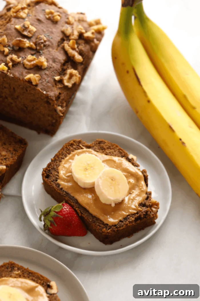 A slice of fluffy vegan banana bread topped with nut butter, ready to be enjoyed.