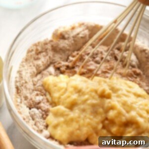 Dry ingredients being slowly added to wet ingredients for banana bread batter.