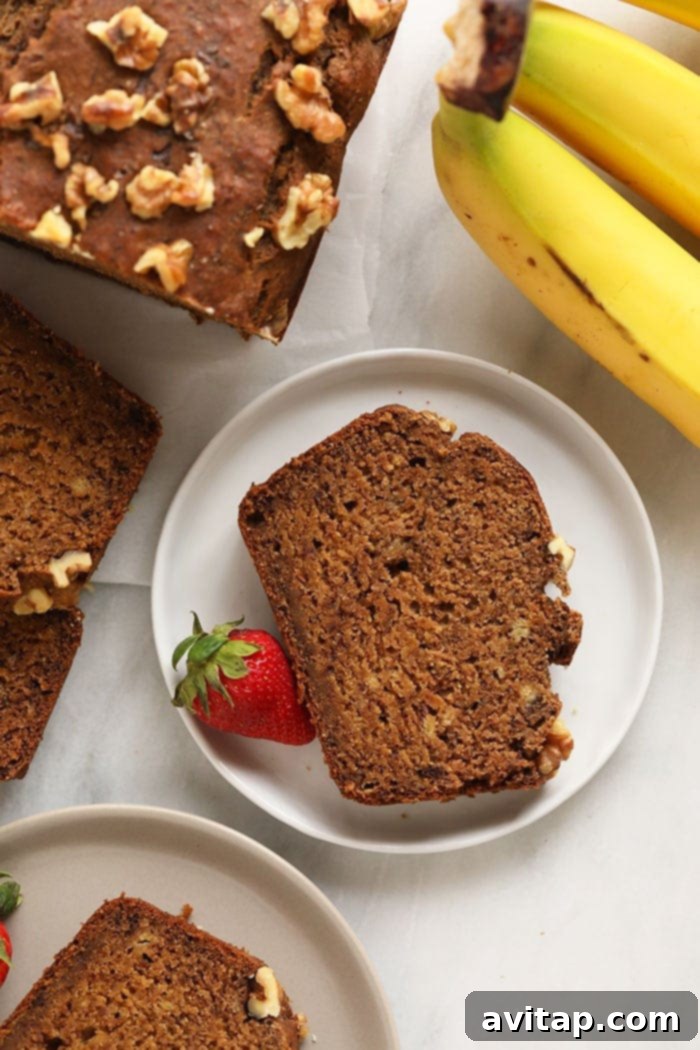 A beautiful slice of vegan banana bread presented on a white plate, ready to be enjoyed.