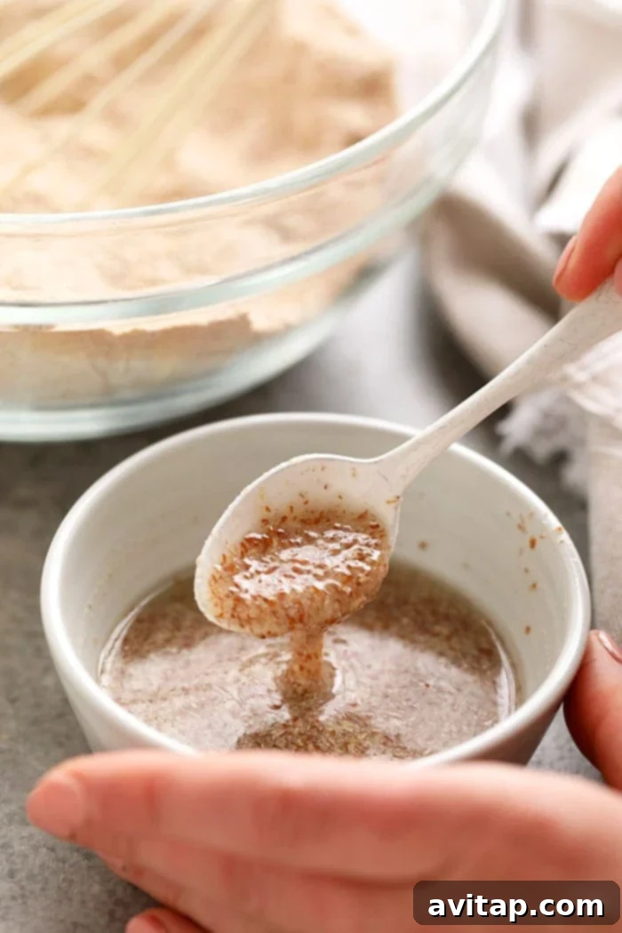 A prepared flax egg in a bowl with a spoon, demonstrating its thick, gelatinous texture.