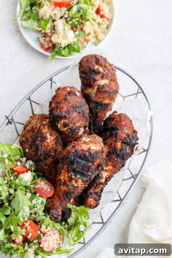 A serving of grilled chicken legs in a basket, accompanied by a fresh salad, ready to be enjoyed.