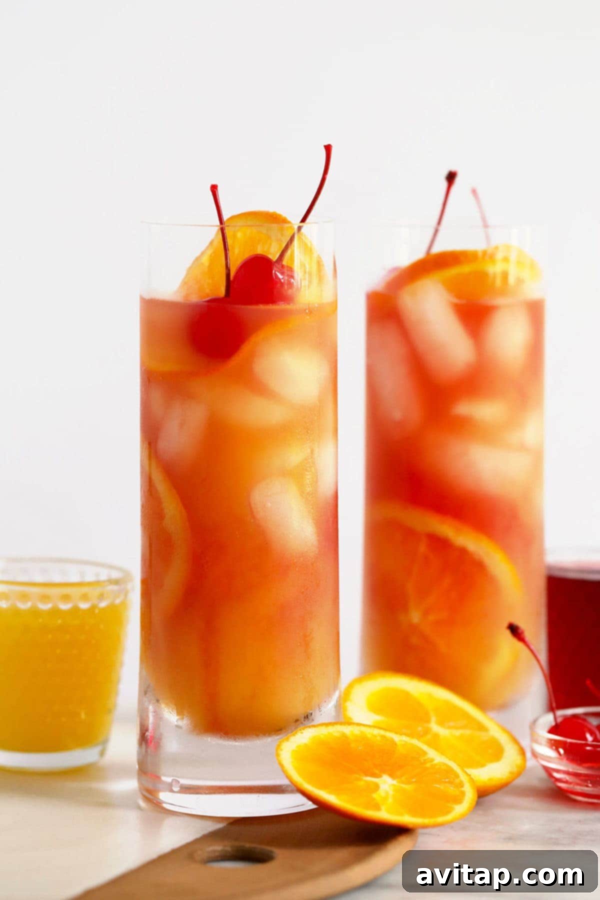 Two glasses of Sex on the Beach cocktail with ice and orange slices.