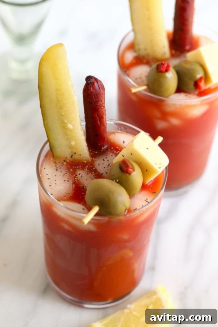 A close-up shot of a magnificent Bloody Mary cocktail, expertly garnished with a pickle, green olives, a beef stick, and cheese, ready to be enjoyed.