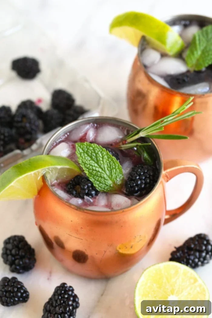 Ice-cold Blackberry Moscow Mule garnished with fresh berries and mint