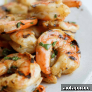 Grilled shrimp on a plate with lemon wedges, marinated.