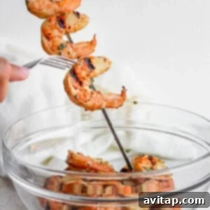 Grilled shrimp skewers in a glass bowl with cilantro.