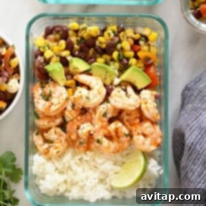 Grilled shrimp in a meal prep bowl with rice and salad.