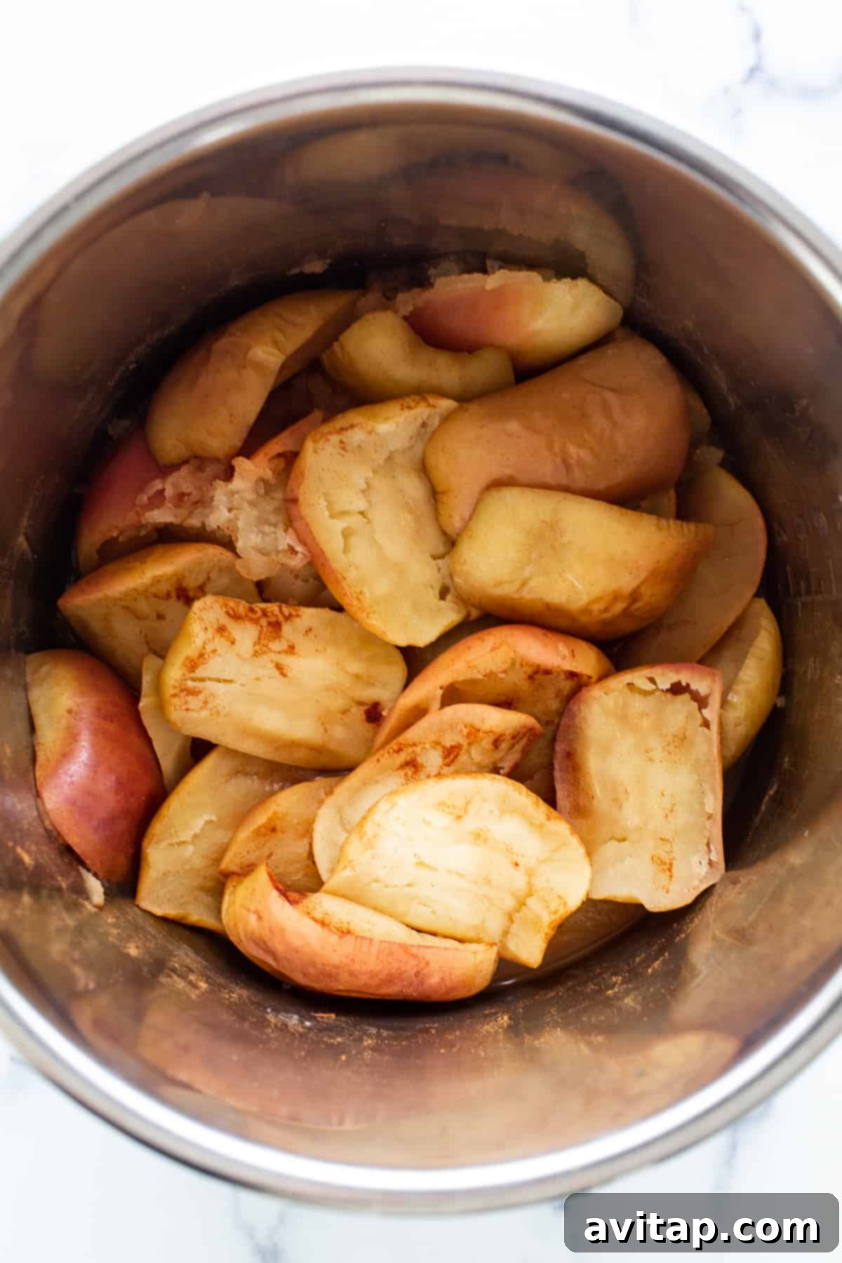 Three simple ingredients: apples, orange juice, and cinnamon sticks for homemade applesauce.
