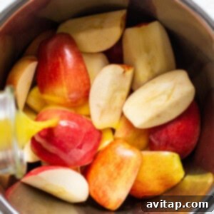 Sliced apples being placed into an Instant Pot, with orange juice poured over them.