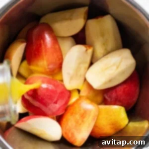 Sliced apples in a bowl with a liquid pouring over them.