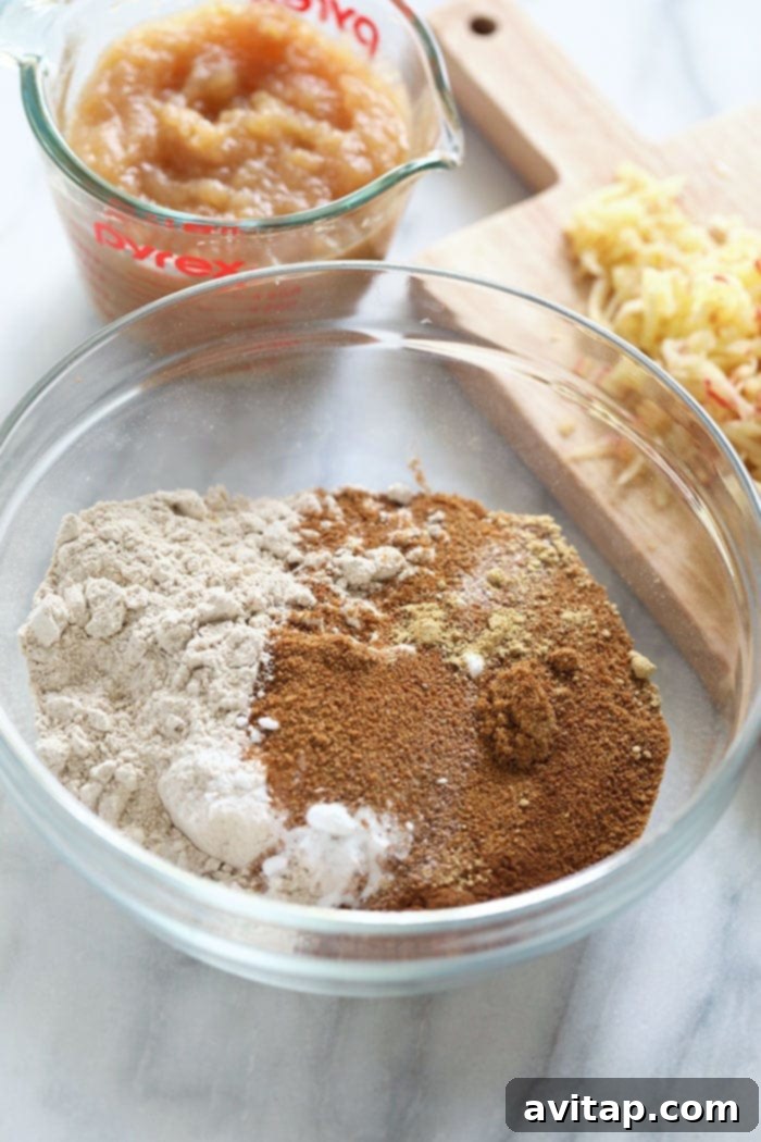 Fresh ingredients for apple cinnamon bread laid out in a bowl, ready for mixing.