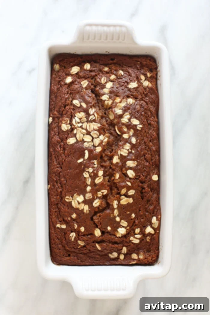 A freshly baked loaf of apple cinnamon bread cooling in a loaf pan.