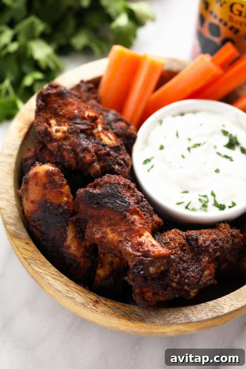 Perfectly Crispy Dry Rub Chicken Wings with Blue Cheese Dip Platter of crispy dry rub chicken wings with a side of creamy blue cheese dip and fresh celery sticks.