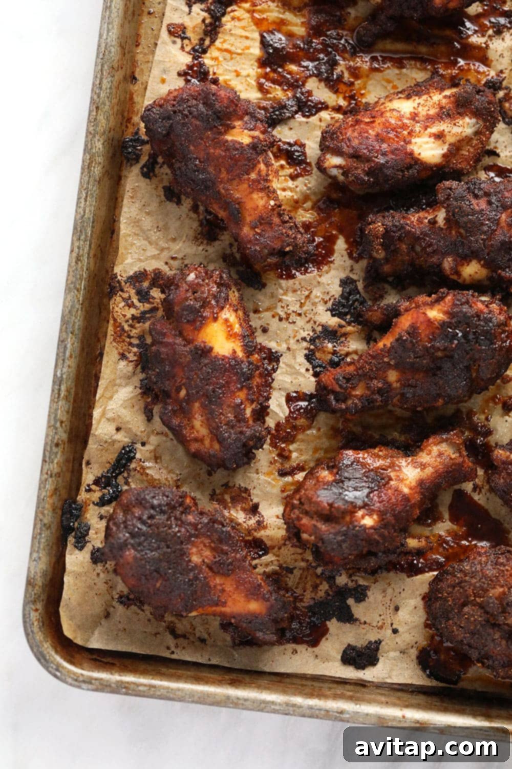 Baked Crispy Dry Rub Chicken Wings A plate piled high with golden-brown, crispy dry rub chicken wings, fresh out of the oven.