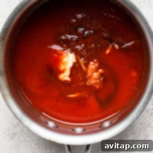 All ingredients for homemade BBQ sauce combined in a saucepan on the stove.