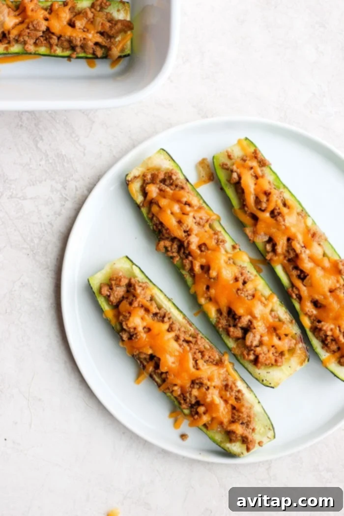 Delicious low-carb Taco Zucchini Boats on a white plate, garnished with fresh cilantro, ready to be enjoyed.