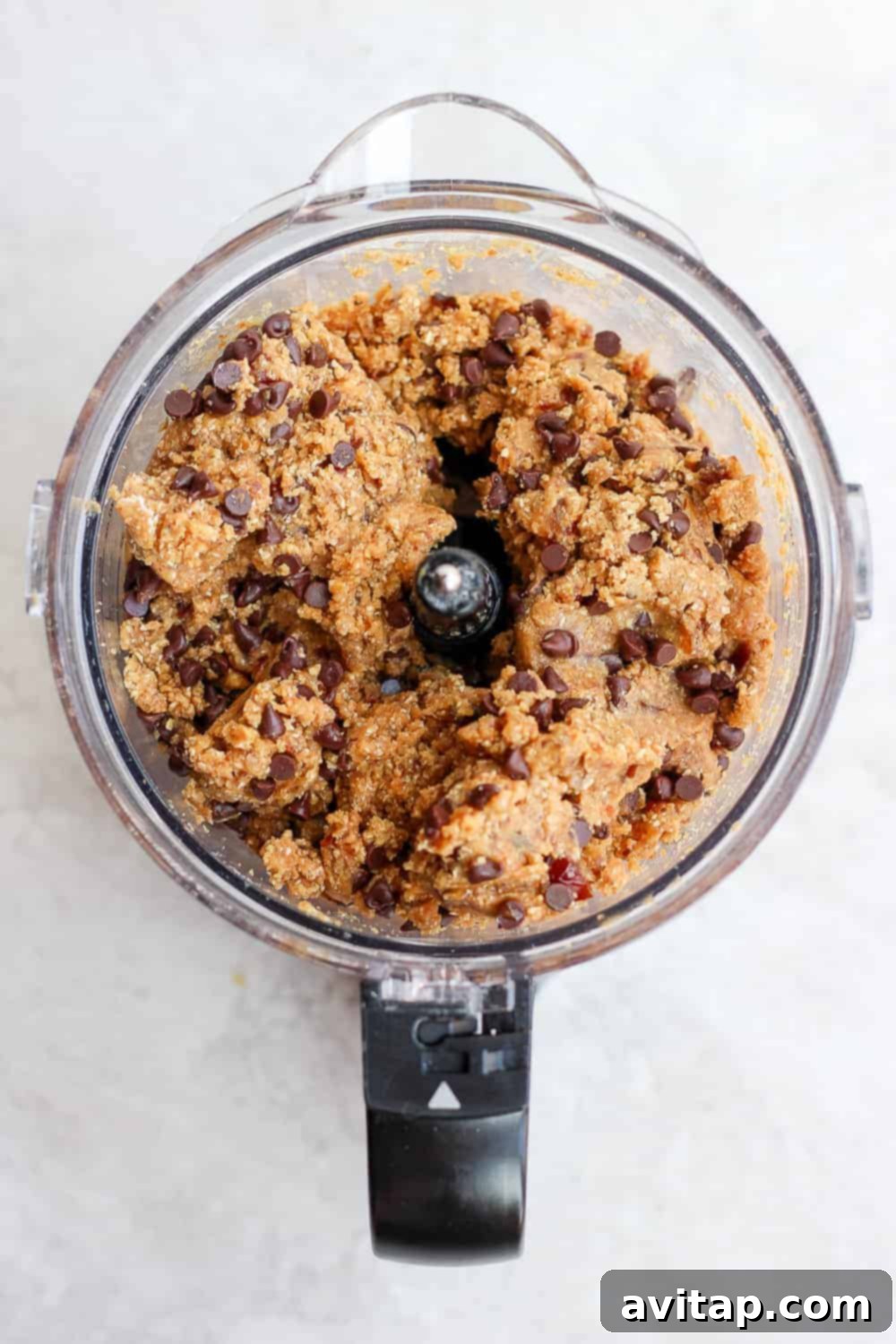 Freshly blended cookie dough in a food processor, showing its smooth, cohesive texture.