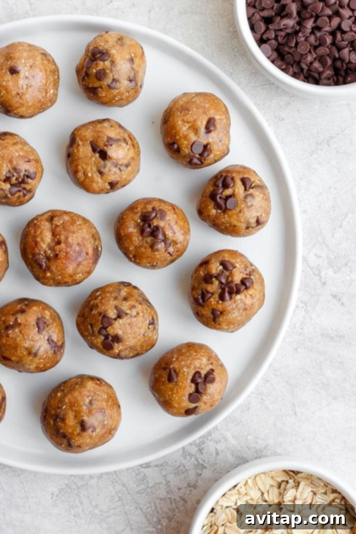 A small stack of perfectly formed cookie dough energy balls on a white plate, ready to be enjoyed.