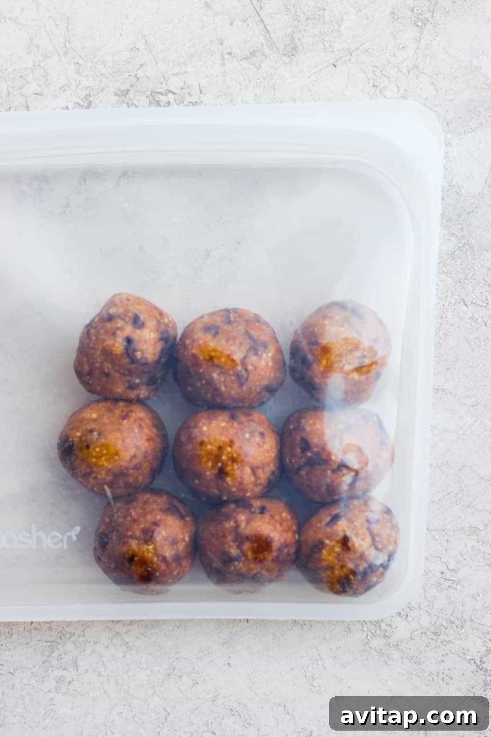 Several cookie dough energy bites stored neatly inside a clear, reusable Stasher bag, ready for grab-and-go snacking.