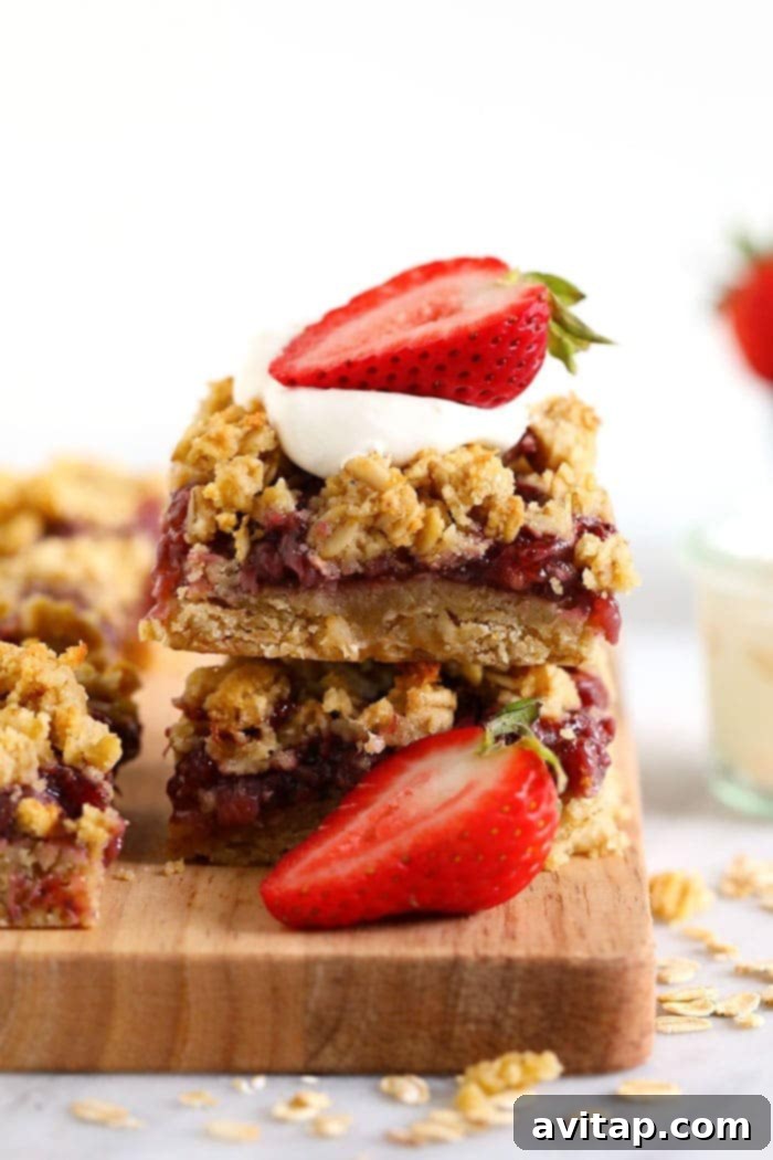 healthy strawberry oatmeal bars stacked and topped with fresh strawberries