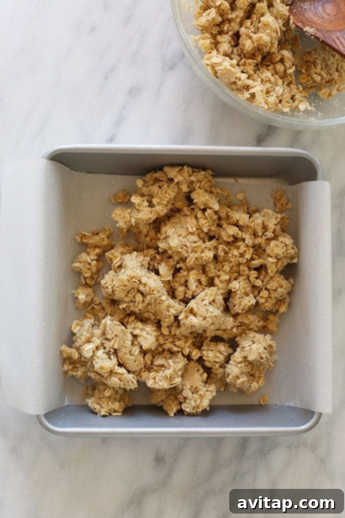 crust and crumble topping in a baking dish with parchment paper