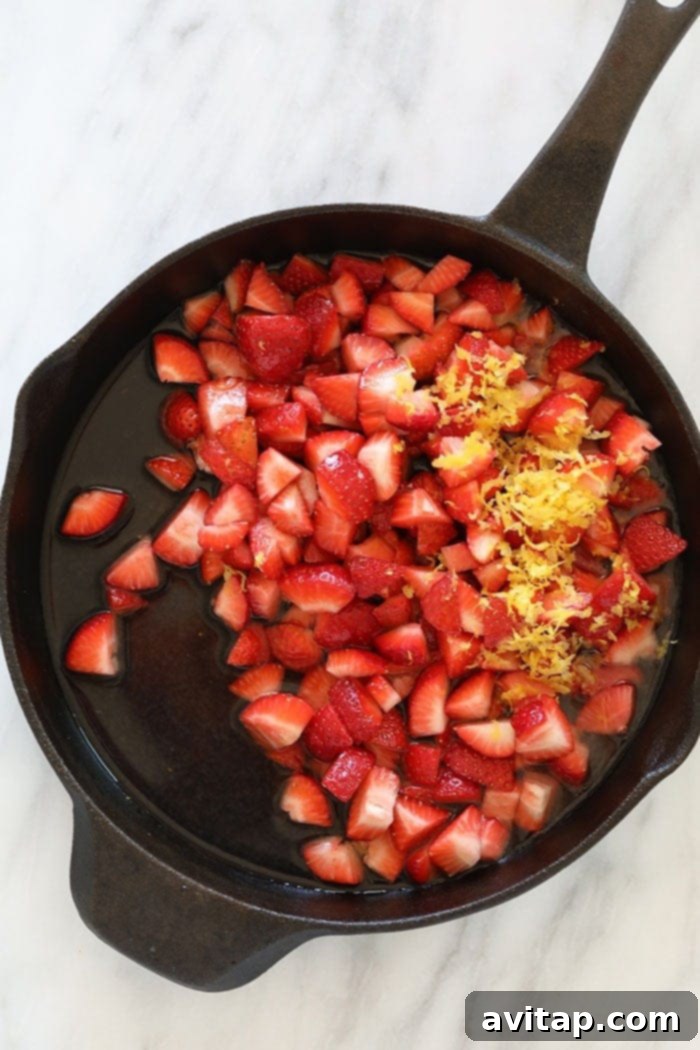 sliced strawberries in a cast iron skillet ready to be reduced