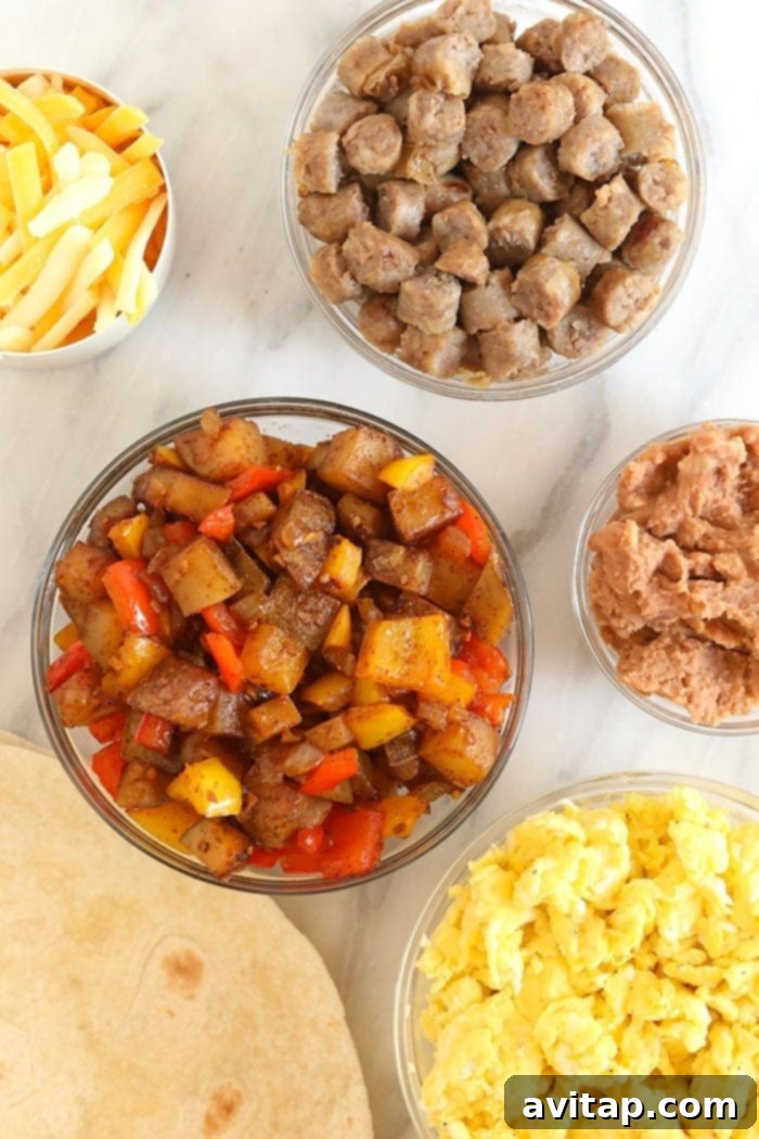 Individual ingredients for fajita breakfast burritos laid out neatly in separate bowls.