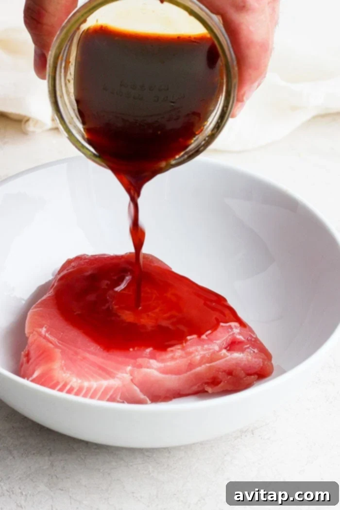 pouring marinade onto an ahi tuna steak