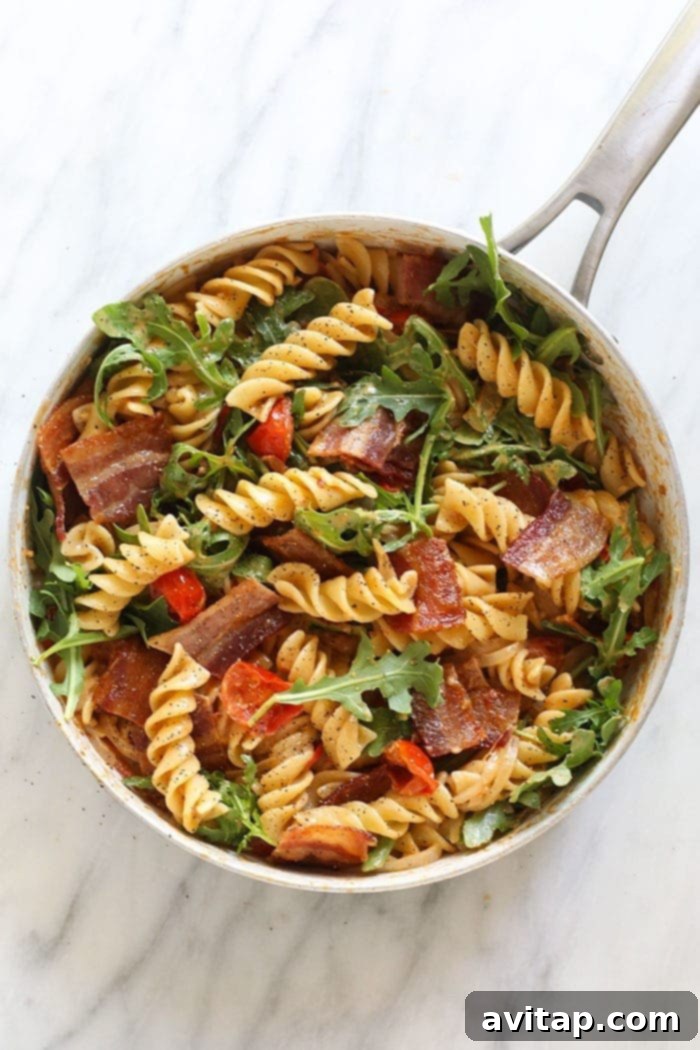 Delicious Healthy BLT Pasta ready for serving. Finished Healthy BLT Pasta in a skillet, garnished with fresh herbs and ready to be served
