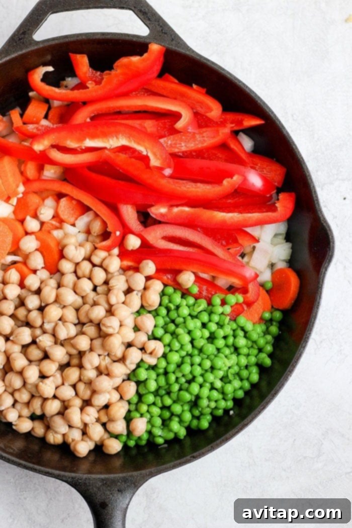 Assorted creamy cashew curry vegetables sautéing in a cast iron skillet.