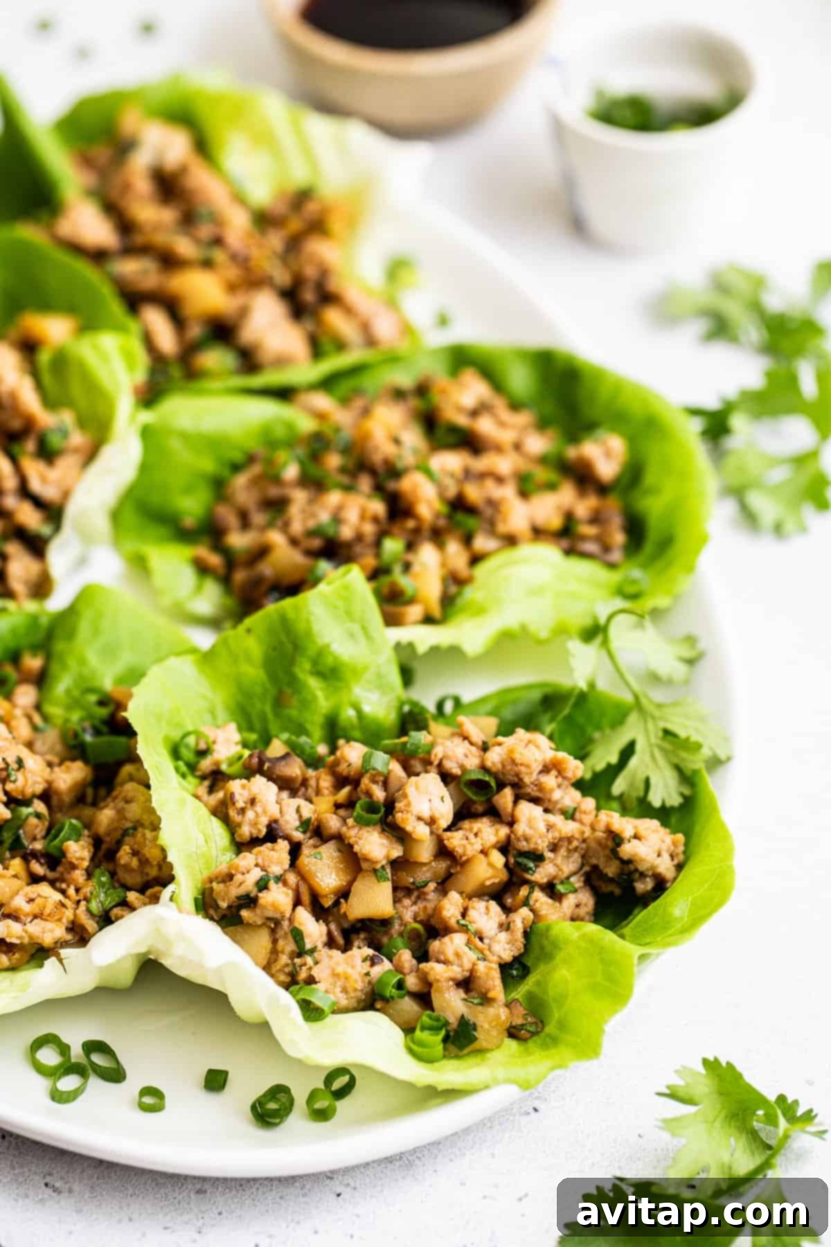 Delicious and fresh chicken lettuce wraps on a white platter, ready to be served.