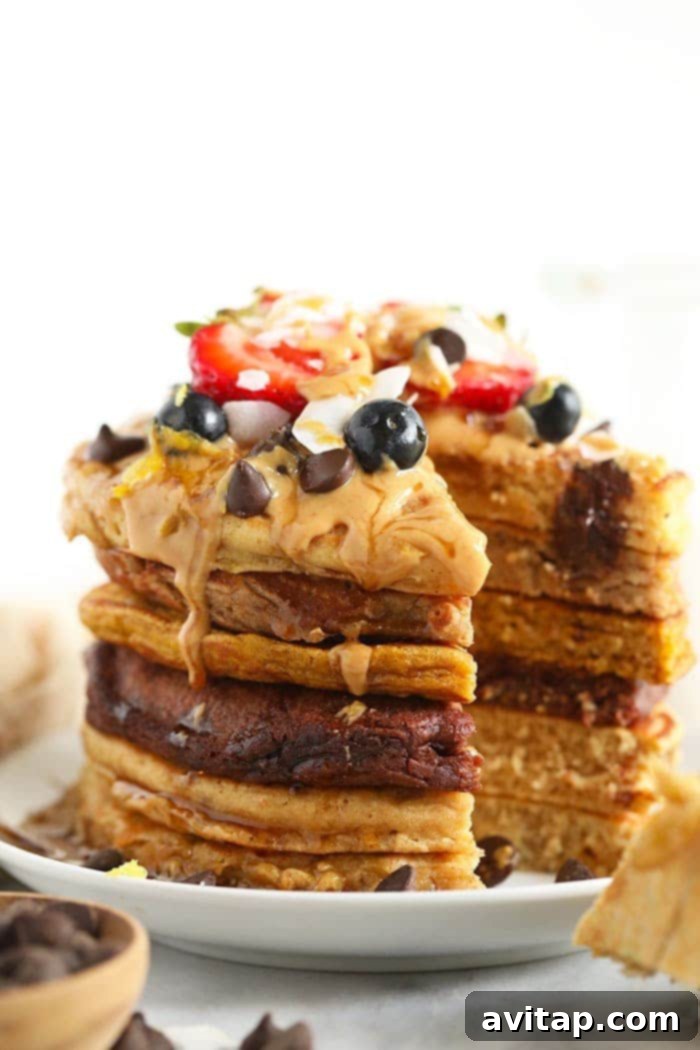 Colorful and healthy pancake stack adorned with fresh fruit. A vibrant stack of healthy pancakes with mixed berry toppings.
