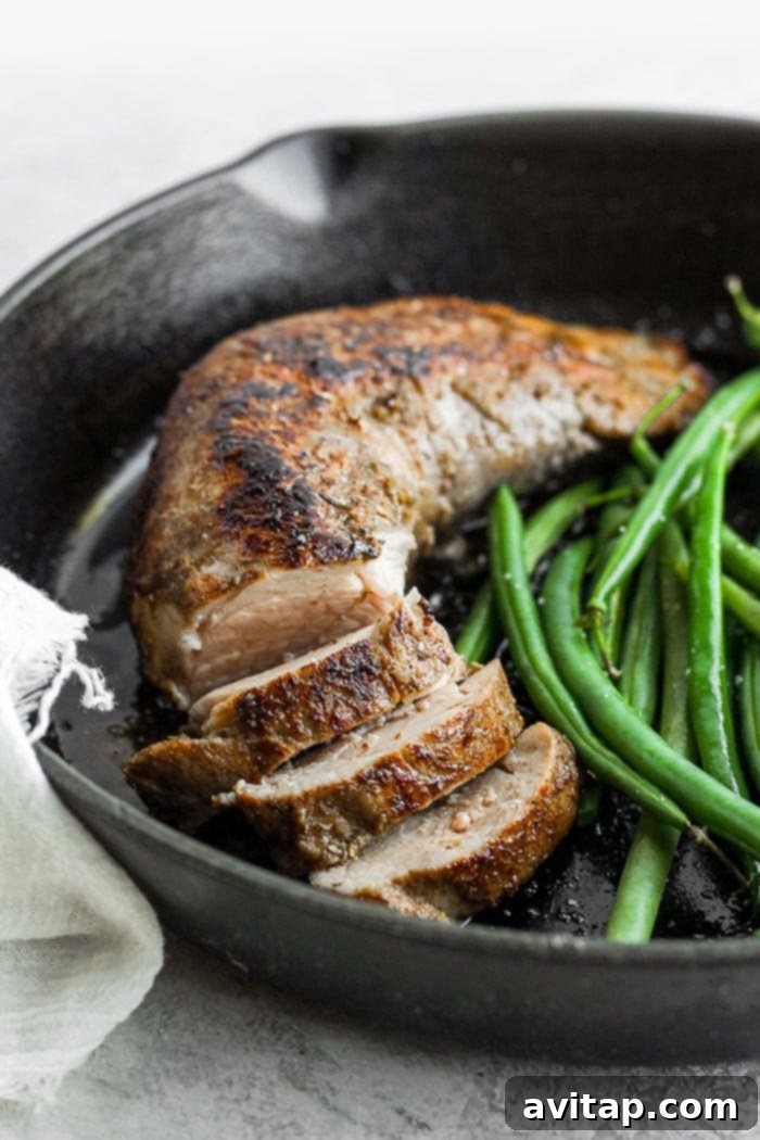 Perfectly seared sous vide pork tenderloin in a cast iron skillet.