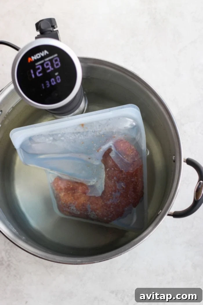 Sous vide pork tenderloin cooking in a water bath with an immersion circulator.
