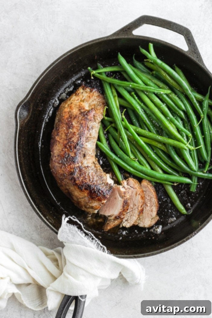 Sliced sous vide pork tenderloin served with vibrant green beans on a plate.