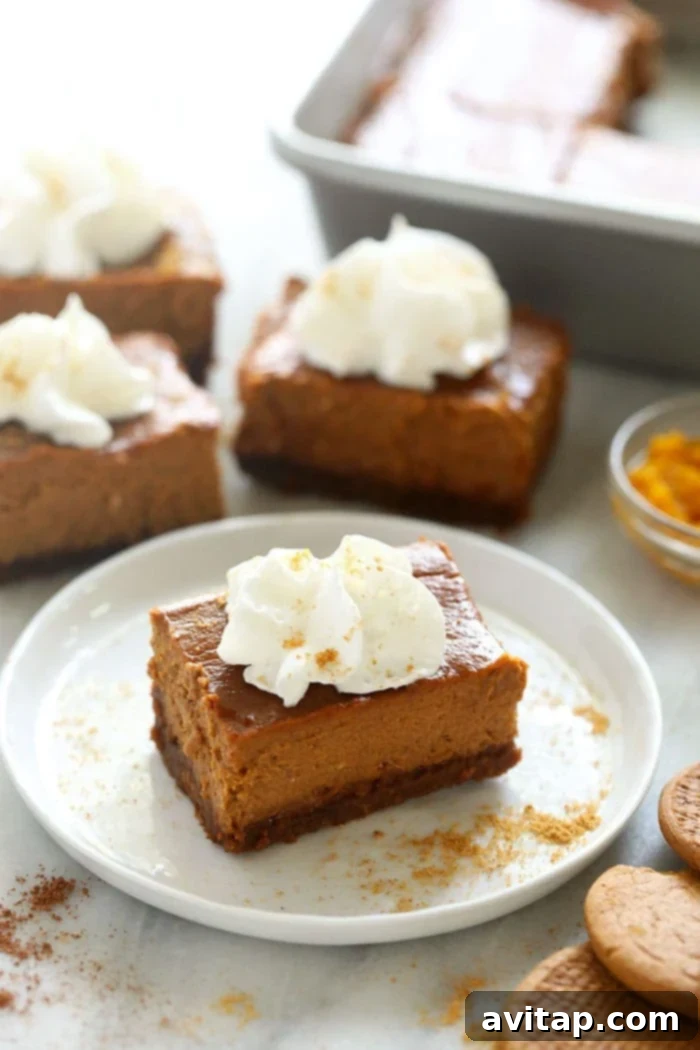 Delicious Pumpkin Cheesecake Bar with Whipped Cream Pumpkin cheesecake bar topped with whipped cream on a plate, ready to be enjoyed.