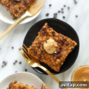 A close-up of a square slice of pumpkin baked oatmeal, with a golden-brown top and visible oats and pumpkin