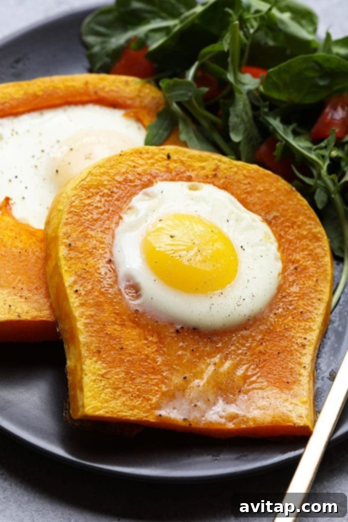 Close-up of a butternut squash egg in a frame on a plate, garnished with herbs
