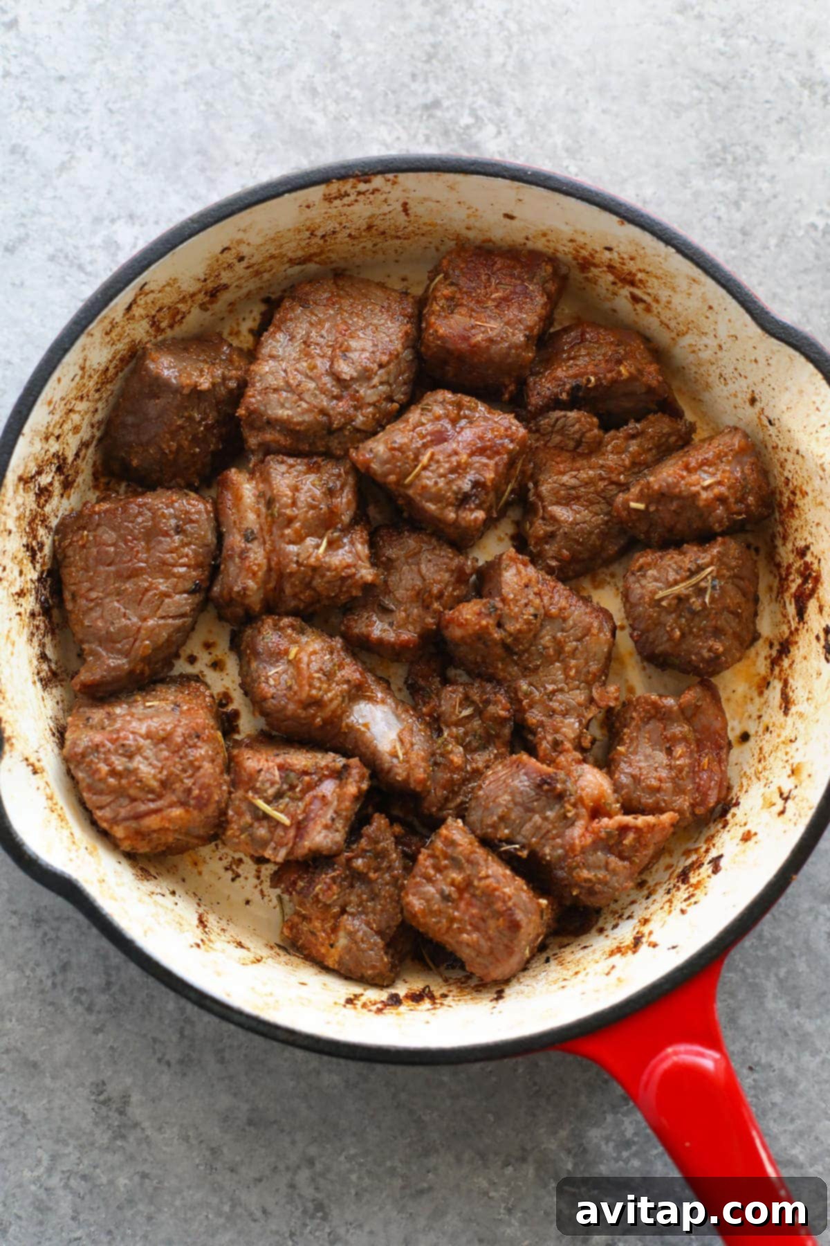 Beef stew meat being expertly browned in a hot skillet, a crucial step for flavor development.